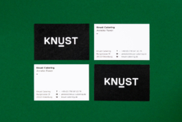 Vier Visitenkarten auf grünem Hintergrund.